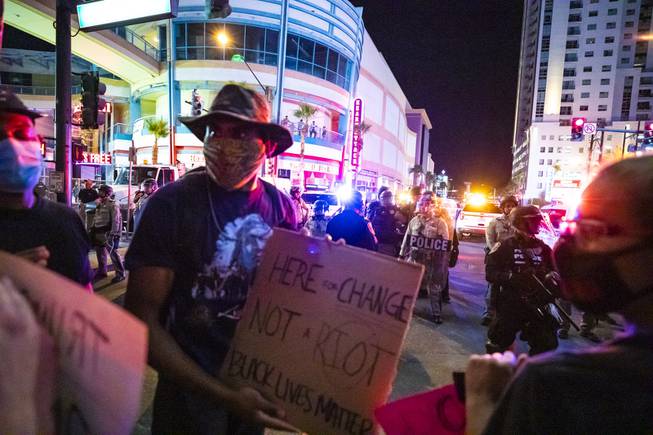 A protester, center, informs Jorge Gomez (not pictured) on how to peacefully protest, Monday, June 1, 2020 in downtown Las Vegas, during the fourth night of protests over the death of George Floyd, a black man who was killed while in Minneapolis police custody. Gomez’s anti-Trump sign can be seen in the lower left corner of the image. 