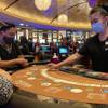 From left, Evan Savar, Nabu Reyes and dealer Leah Prerost are shown at a Red Rock Resort blackjack table just after the casino opened, Thursday, June 4, 2020. 
