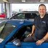 Bill Bosnos, general manager at Friendly Ford, poses by a 2020 Ford Mustang EcoBoost coupe outside the dealership showroom Thursday, June 18, 2020. The dealership moved the cars outside the showroom to make it safer for shoppers during the pandemic, he said. 