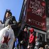 In this Nov. 29, 2019, file photo a shopper leaves Macy's department store with bags in both hands during Black Friday shopping in New York.