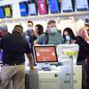 A couple uses a self-service kiosk to check in for a flight at McCarran International Airport Thursday, July 2, 2020.