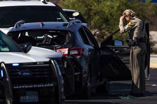 A Metro police officer surveys the scene of a valley wide pursuit that ended with a suspect committing suicide on Las Vegas Blvd and Blue Diamond Rd, Saturday, July 11, 2020.