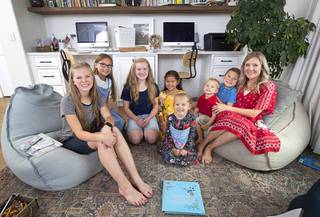 Austin Okuda, right, poses with her children in a homeschooling study room at their home Tuesday, July 21, 2020. Children from left: Kennedy, 15, Elynn, 12, Leah, 14, Macee, 9, Malin5, Oliver, 3, and Emmett, 7.