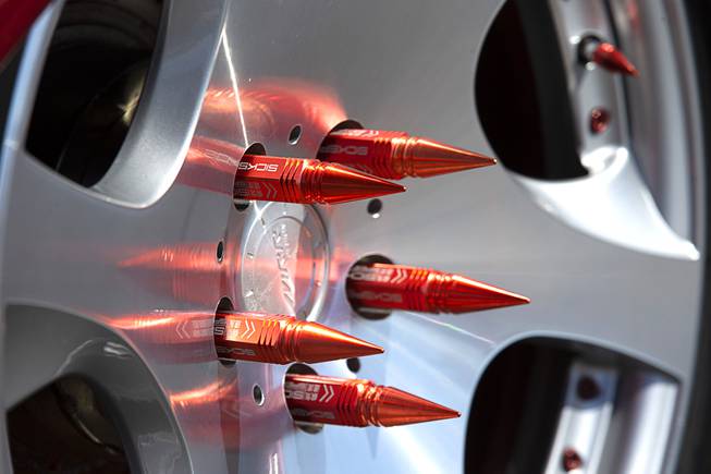 Customized lug nuts are shown on a car during a ...