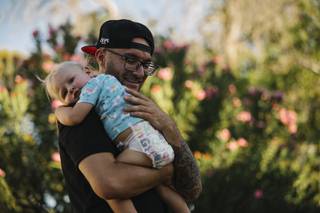Recovered heroin addict Angelo Calabrese holds his sponsor Paul Vautrinot's baby daughter Keira Vautrinot, Tuesday, July 28, 2020.