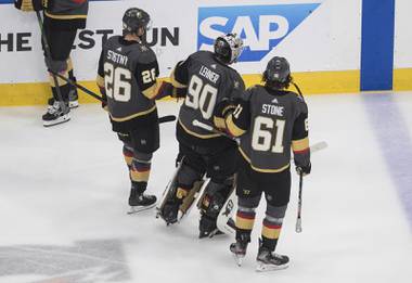 Vegas Golden Knights goalie Robin Lehner (90) is helped to the bench by Mark Stone (61) and Paul Stastny (26) after losing a skate blade during the second period against the Chicago Blackhawks in Game 1 of an NHL hockey Stanley Cup first-round playoff series, Tuesday, Aug. 11, 2020, in Edmonton, Alberta. (Jason Franson/The Canadian Press via AP)