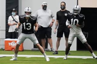 Las Vegas Raiders wide receiver Hunter Renfrow (13) and wide receiver Rico Gafford (10) warm up during an NFL football training camp practice Tuesday, Aug. 18, 2020, in Henderson, Nev. (AP Photo/John Locher, Pool)