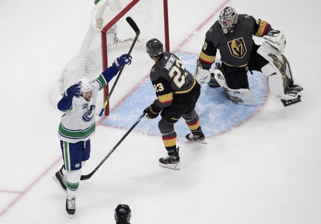 Vegas Golden Knights goalie Robin Lehner (90) is scored on as Vancouver Canucks' Alexander Edler (23) celebrates and Alec Martinez (23) defends during the first period of an NHL Western Conference Stanley Cup playoff game in Edmonton, Alberta, on Tuesday, Aug. 25, 2020. (Jason Franson/The Canadian Press via AP)