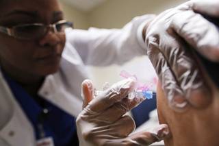 Registered Nurse Claudina Prince administers a flu shot at a Dekalb County health center in Decatur, Ga., Monday, Feb. 5, 2018. The U.S. government's latest flu report released on Friday, Feb. 2, 2018, showed flu season continued to intensify the previous week, with high volumes of flu-related patient traffic in 42 states, up from 39 the week before. (AP Photo/David Goldman)