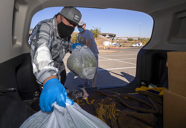 Humberto Sandoval, left, and Michael Nelson load food into a ...
