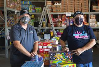Greg Bortles, left, a board member, and Dale Darcas, founder and executive director, pose with donated food in the Serving Our Kids Foundation warehouse in Henderson Saturday, Sept. 12, 2020.