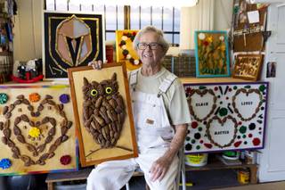 Raymond George Chicoine, 88, poses for a photo in front of his display of pine cone art in his garage workshop, Wednesday, Sept. 16, 2020.