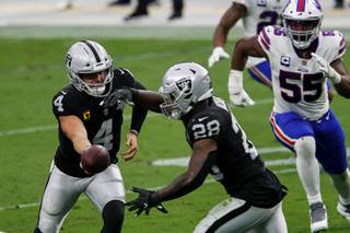 Las Vegas Raiders quarterback Derek Carr (4) hands off the ball to running back Josh Jacobs (28) during the second half of their game against the Buffalo Bills at Allegiant Stadium Sunday, Oct. 4, 2020.