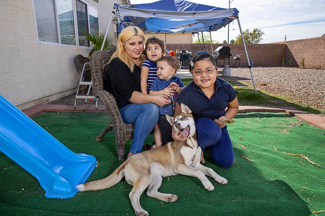 Yanneth Romero, a Mandalay Bay housekeeper who hasn't been called back to work, poses with her children and the family dog Lily in the backyard of her rental home in North Las Vegas Friday, Oct. 9, 2020. Children from left: Kyana, 2, Octavio, 1, and Kimberly, 7. Her husband is also out of work and his unemployment claim is stuck in the system, she said.