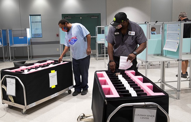 Clark County workers unpack voting machines as they set up ...