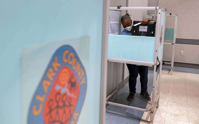 Clark County worker Tameka Balaka sets up a voting machine ...