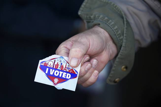 A voter displays his "I Voted" sticker at an early voting site in Henderson Saturday, Oct. 17, 2020.