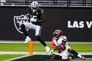 Las Vegas Raiders wide receiver Nelson Agholor (15) scores a touchdown as Tampa Bay Buccaneers cornerback Jamel Dean (35) gets up from the ground during a game at Allegiant Stadium, Sunday, Oct. 25, 2020.