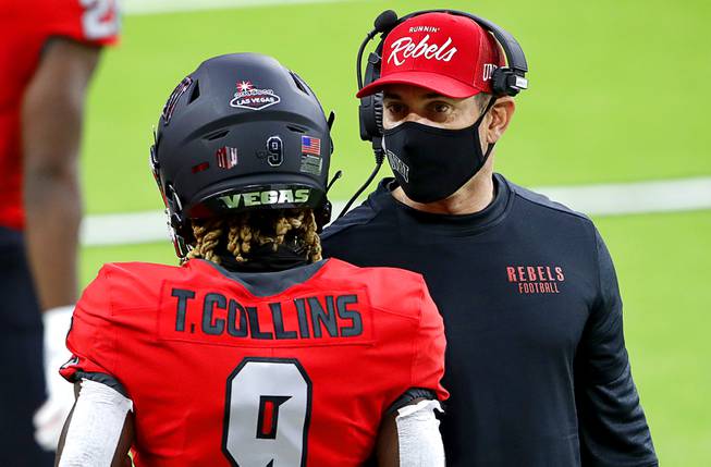UNLV Rebels head coach Marcus Arroyo talks with wide receiver Tyleek Collins (9) before a game against the Fresno State Bulldogs at Allegiant Stadium Saturday, Nov. 7, 2020.