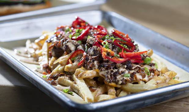 Hangover Fries are shown at 595 Craft and Kitchen at Rainbow Boulevard and Tropicana Avenue Wednesday, Nov. 11, 2020. Hangover Fries are homemade fries topped with ground beef, pickled Fresno chiles, caramelized onions onions and bacon.