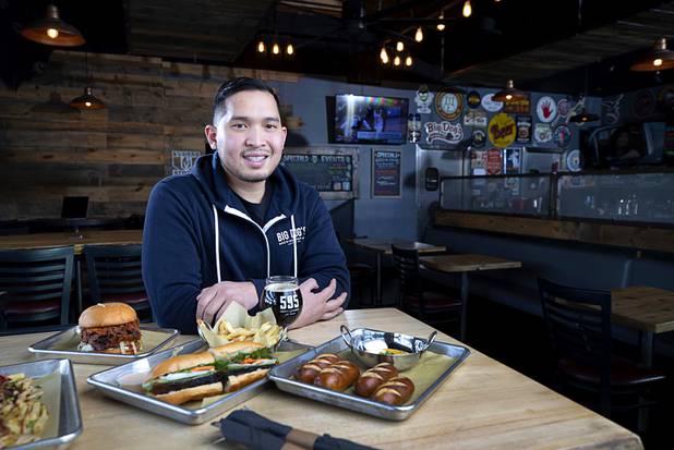 Van-Alan Nguyen, owner of 595 Craft and Kitchen and Art District Kitchen, poses in 595 Craft at Rainbow Boulevard and Tropicana Avenue Wednesday, Nov. 11, 2020. Dishes include a Nashville-style Hot Chicken Sandwich, left, a Pork Belly Banh Mi, center, and Beer Cheese with Soft Pretzels.