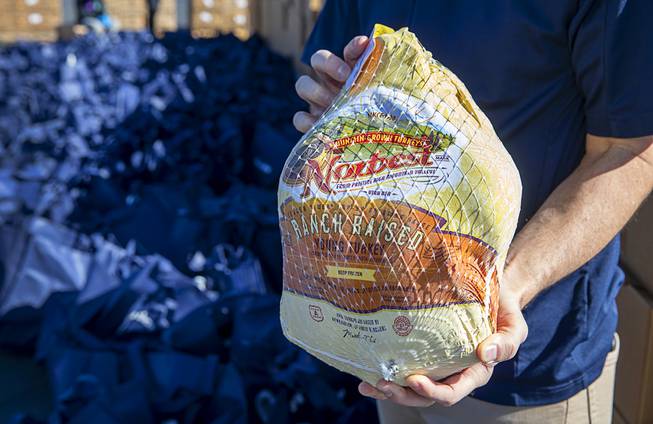 Clark County Commissioner Justin Jones holds a frozen turkey before ...