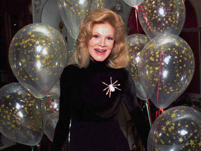 Singer Phyllis McGuire, 64, the youngest of The McGuire Sisters, smiles after receiving a cluster of balloons from longtime friends Debbie Reynolds and Rip Taylor at her home in Las Vegas, Tuesday, Dec. 12, 1995.