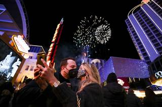 A couple takes a selfie as fireworks explode over the Plaza in downtown Las Vegas, Friday, Jan. 1, 2021.