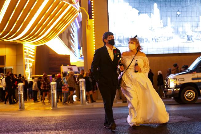 Newlyweds Jackie McCafferty, left, and Janell Menard, depart after watching a fireworks show over the Plaza Casino, downtown, Friday, Jan 1, 2021.