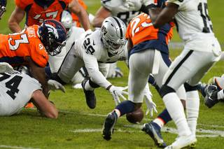 Las Vegas Raiders running back Josh Jacobs (28) recovers his own fumble against the Denver Broncos during the first half of an NFL football game, Sunday, Jan. 3, 2021, in Denver. 


