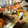 Dharmi Patel assembles an order at the South Point hot dog cart on Wednesday, Jan. 6, 2021. The popular cart offers Vienna Beef Chicago hot dogs, steamed in Budweiser, for the bargain price of $1.25 each. 