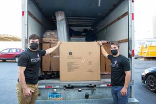 Jack Sellinger and Nick Rupp, employees of the on demand delivery and move service company Move it, load a large box onto a truck as they prepare to deliver an order to a client, Friday Jan 8, 2021.