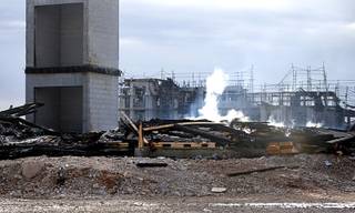 Building materials smolder after an overnight fire destroyed an apartment complex under construction near Tropicana Avenue and Fort Apache Road Tuesday, Jan. 19, 2021. The fire caused an estimated $25 million to $30 million in damage, according to the Clark County Fire Department.