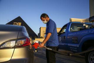 Fuelster delivery technician Mario Gonzalez pumps gas into a car at the Luxor parking garage, Thursday, Jan. 21, 2021.