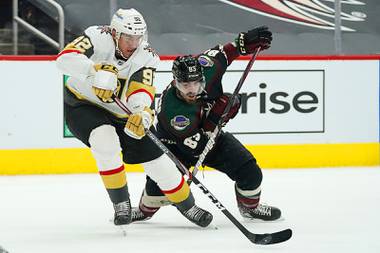 Vegas Golden Knights left wing Tomas Nosek (92) controls the puck in front of Arizona Coyotes right wing Conor Garland (83) during the first period of an NHL hockey game Friday, Jan. 22, 2021, in Glendale, Ariz.