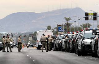 Metro Police cars line Silverado Ranch Boulevard between Pollock Road and Maryland Parkway following an officer-involved shooting Tuesday, Feb. 9, 2021. The suspect in the shooting is believed to be barricaded in an apartment complex.