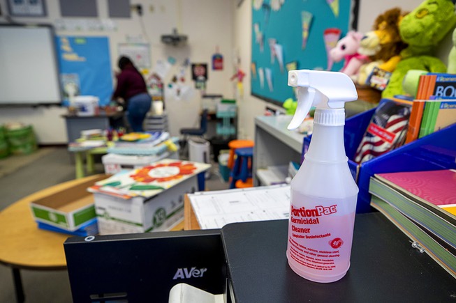 A germicidal spray is shown on a table as custodian ...