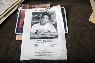 A pamphlet used at Xavier Danaurd Crockett Simms' funeral service is displayed in Debra Simms' apartment Saturday, Feb. 13, 2021. Simms, 15, and friend Jason Moore were killed in 1996. Twenty-five years after the killings, a man has confessed to the murders, police said.