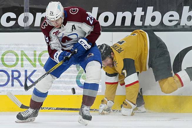 Colorado Avalanche center Nathan MacKinnon (29) vies for the puck with Vegas Golden Knights defenseman Alex Pietrangelo (7) during the third period of an NHL hockey game Sunday, Feb. 14, 2021, in Las Vegas.