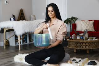 Reiki Master Monej Cruz, owner of Potent Habit, a health and beauty business, uses a singing bowl in her studio, Wednesday, Feb. 10, 2021.