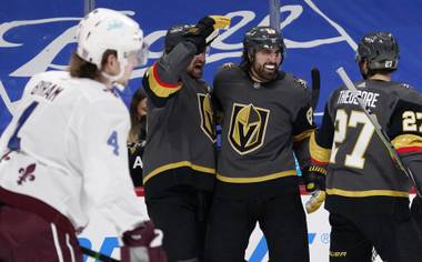 Vegas Golden Knights right wing Alex Tuch, back center, celebrates his goal with right wing Mark Stone, back left, and defenseman Shea Theodore, back right, as Colorado Avalanche defenseman Bowen Byram, front, heads back to the team box in the second period of an NHL hockey game Monday, Feb. 22, 2021, in Denver. (AP Photo/David Zalubowski)