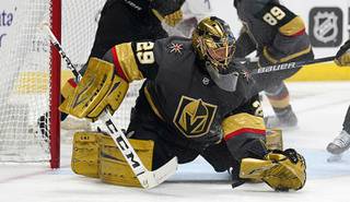 Vegas Golden Knights goaltender Marc-Andre Fleury makes a glove save of a shot against the Colorado Avalanche in the third period of an NHL hockey game Monday, Feb. 22, 2021, in Denver.