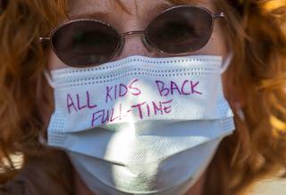 Misty Lucina wears a message on her mask as she rallies with other parents before a meeting of the Clark County School Board at the Lowden Theater in downtown Las Vegas Thursday, Feb. 25, 2021. Many parents and students were asking for an immediate full-time return of students to the classroom.