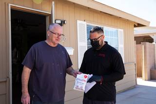 Gabriel Rivero, a delivery driver for First Class RX Pharmacy, hand delivers a prescription to a patient Wed. Feb 24, 2021.