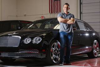 Cory McCormack, owner of All Star Cars, poses for a photo next to a Bentley Flying Spur W12 Mulliner, Friday, Feb. 26, 2021.