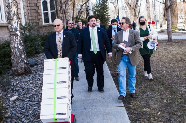 The Nevada GOP and supporters at the State Capitol haul a cart carrying what they described as 120,000 "election integrity violation reports" alleging widespread voter fraud during the 2020 election.