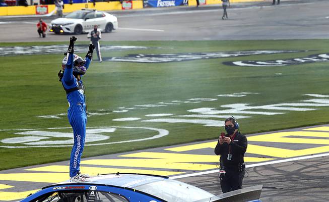 NASCAR Cup Series driver Kyle Larson stands on his car after winning the Pennzoil 400 presented by Jiffy Lube NASCAR Cup Series race at the Las Vegas Motor Speedway Sunday, March 7, 2021.
