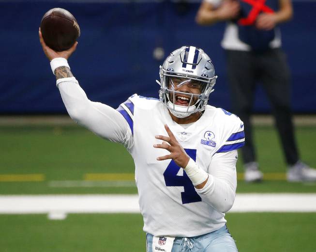 In this Oct. 11, 2020, file photo, Dallas Cowboys quarterback Dak Prescott throws a pass in the first half of an NFL football game against the New York Giants in Arlington, Texas. 