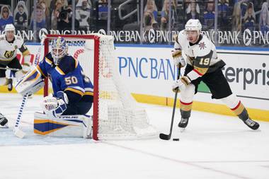 Vegas Golden Knights’ William Karlsson (71) tries to get off a shot as St. Louis Blues’ goaltender Jordan Binnington (50) and Sammy Blais (9) defend during the first period of an NHL hockey game Friday, March 12, 2021, in St. Louis. (AP Photo/Jeff Roberson)