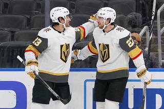 Vegas Golden Knights' Shea Theodore (27) is congratulated by teammate Alec Martinez (23) after scoring during the first period of an NHL hockey game against the St. Louis Blues Saturday, March 13, 2021, in St. Louis.